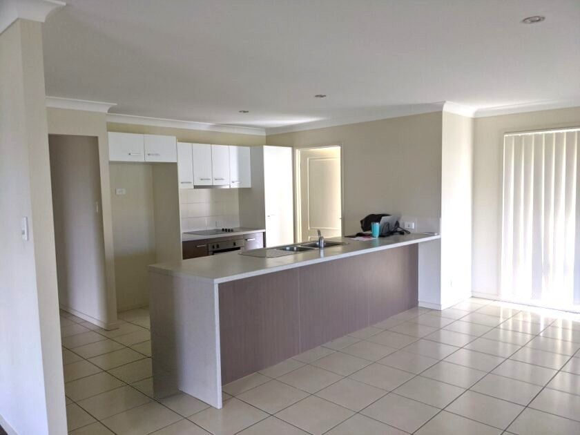 Spacious, accessible open-plan kitchen in Bundaberg SIL Accommodation at 2 Zac Ct, Kalkie QLD 4670, featuring light tiles, modern cabinets, and wide doorways, part of Australia’s leading disability accommodation provider.