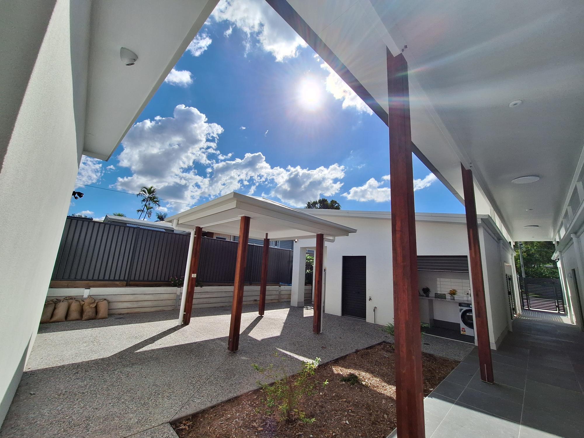 Accessible outdoor courtyard of a SIL in Brand New HPS Villas in Brassall, 14 Hayes St, Brassall Qld 4305, featuring covered walkway, wide pathways, and secure fencing, part of Australia’s leading disability accommodation provider.