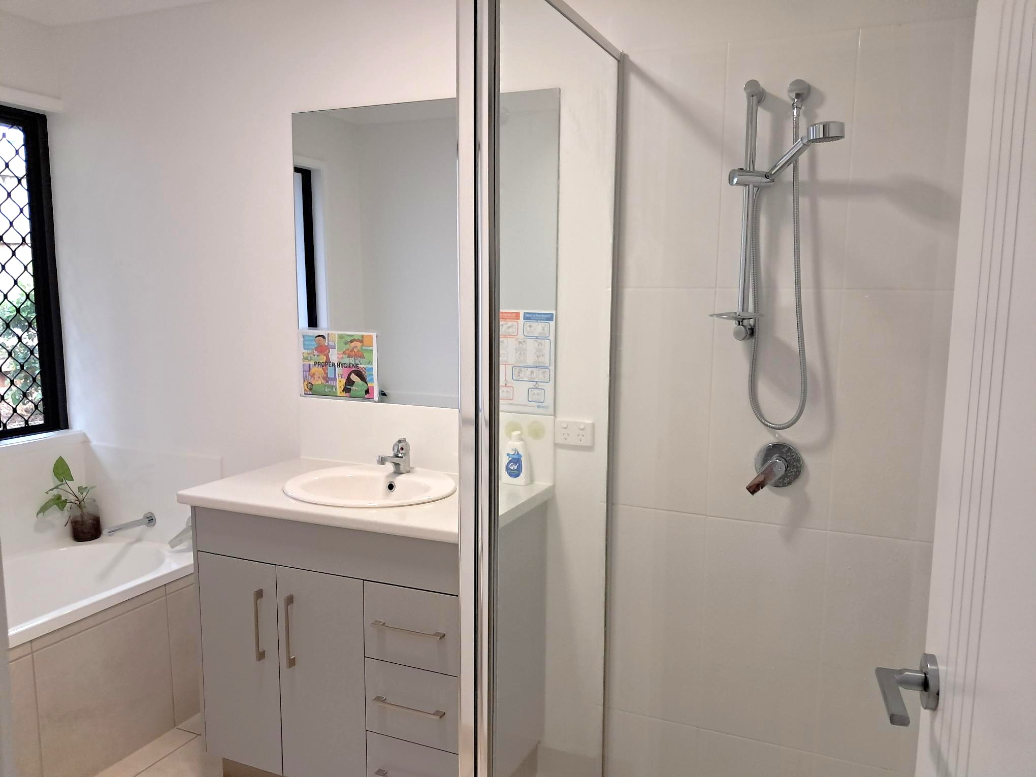 Bathroom with shower, vanity, bathtub, and frosted windows, featuring modern fixtures and fittings, from Australia's leading wholesale lighting supplier.
