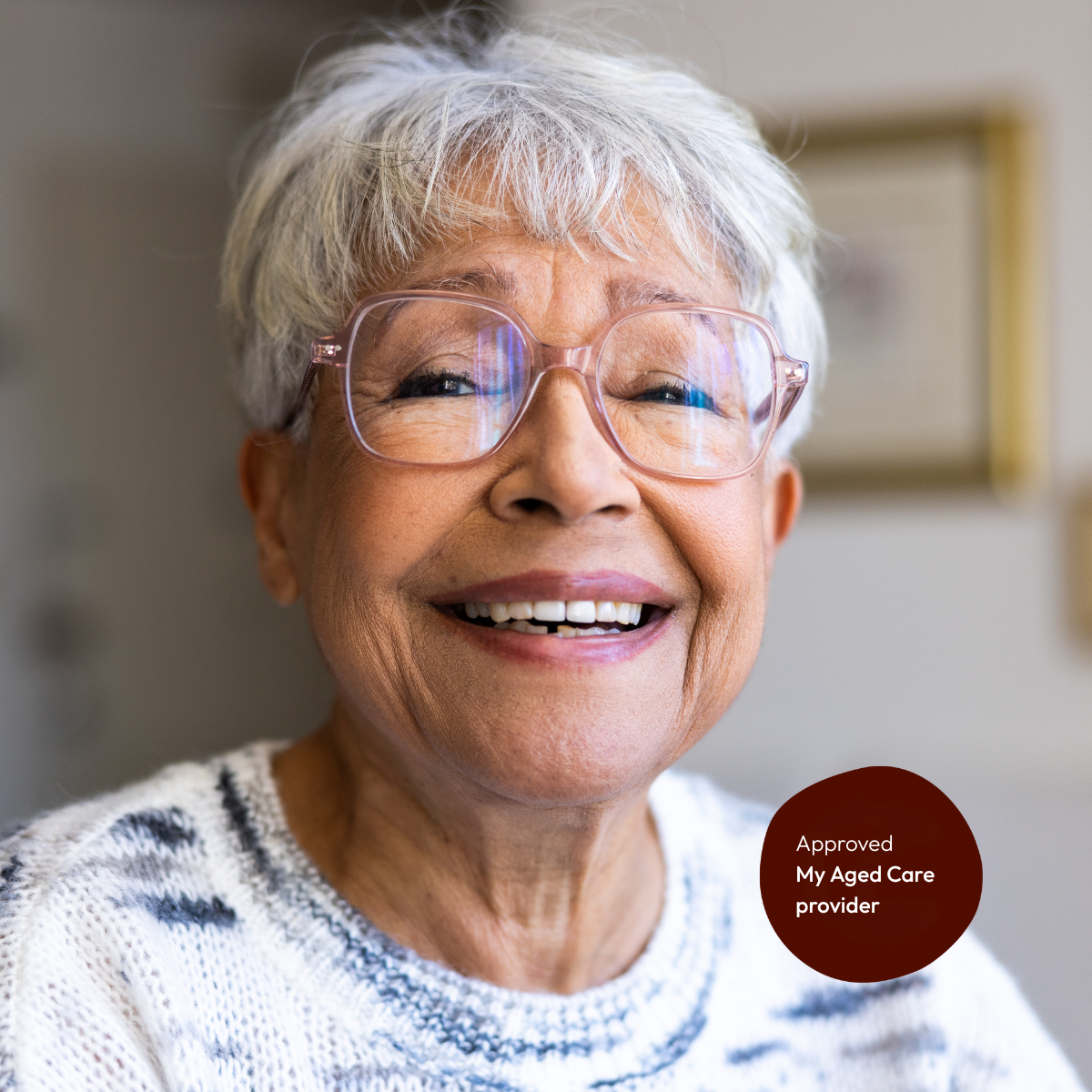Portrait of a senior woman in her home with our approved My Aged Care provider badge