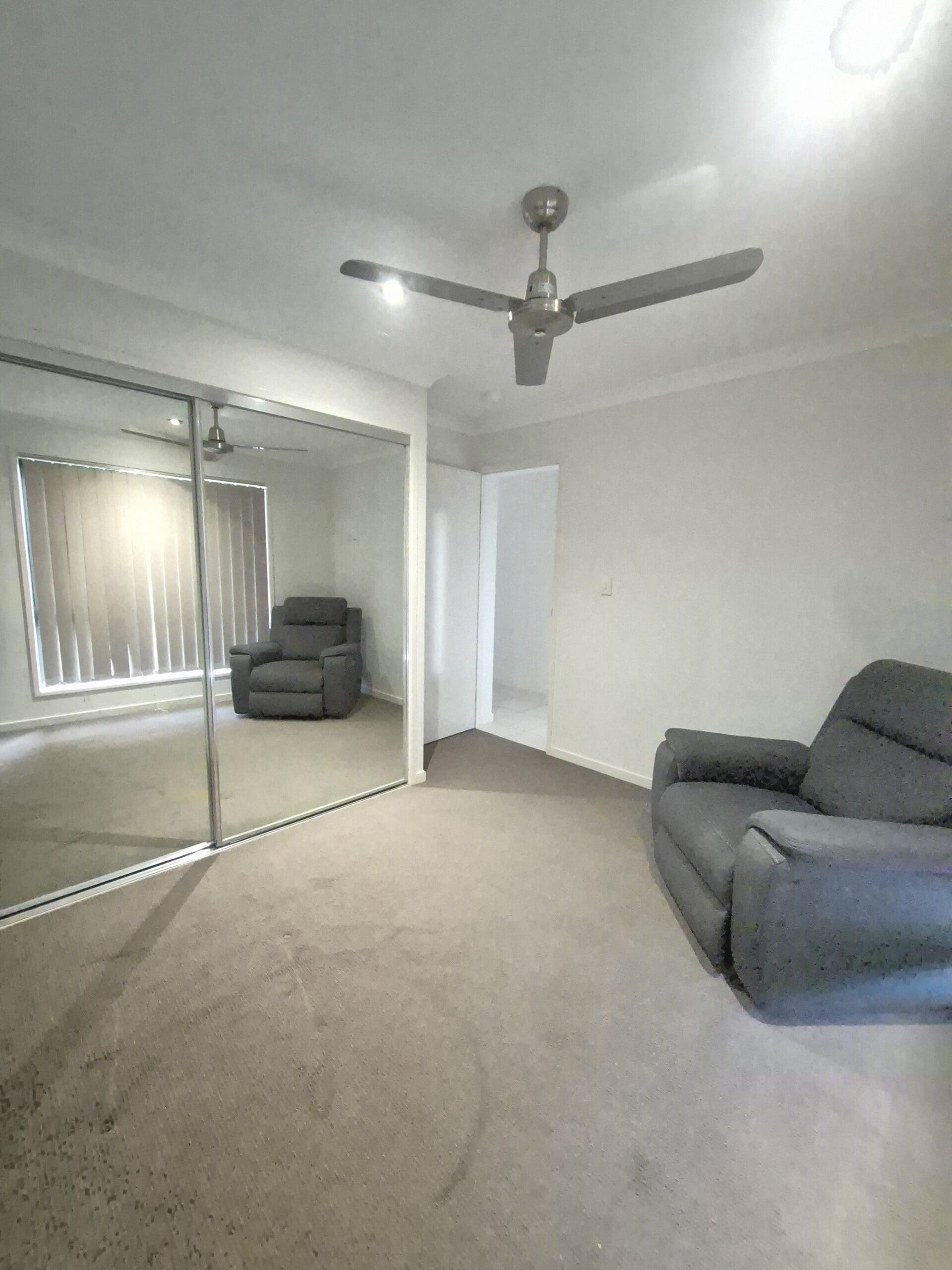 Spacious, accessible bedroom in a Warm and Inviting SIL Home in Parkhurst, 32 Vermont Drive, Parkhurst Qld 4702, featuring grey carpet, mirrored wardrobes, and ceiling fan, part of Australia’s leading disability accommodation provider.