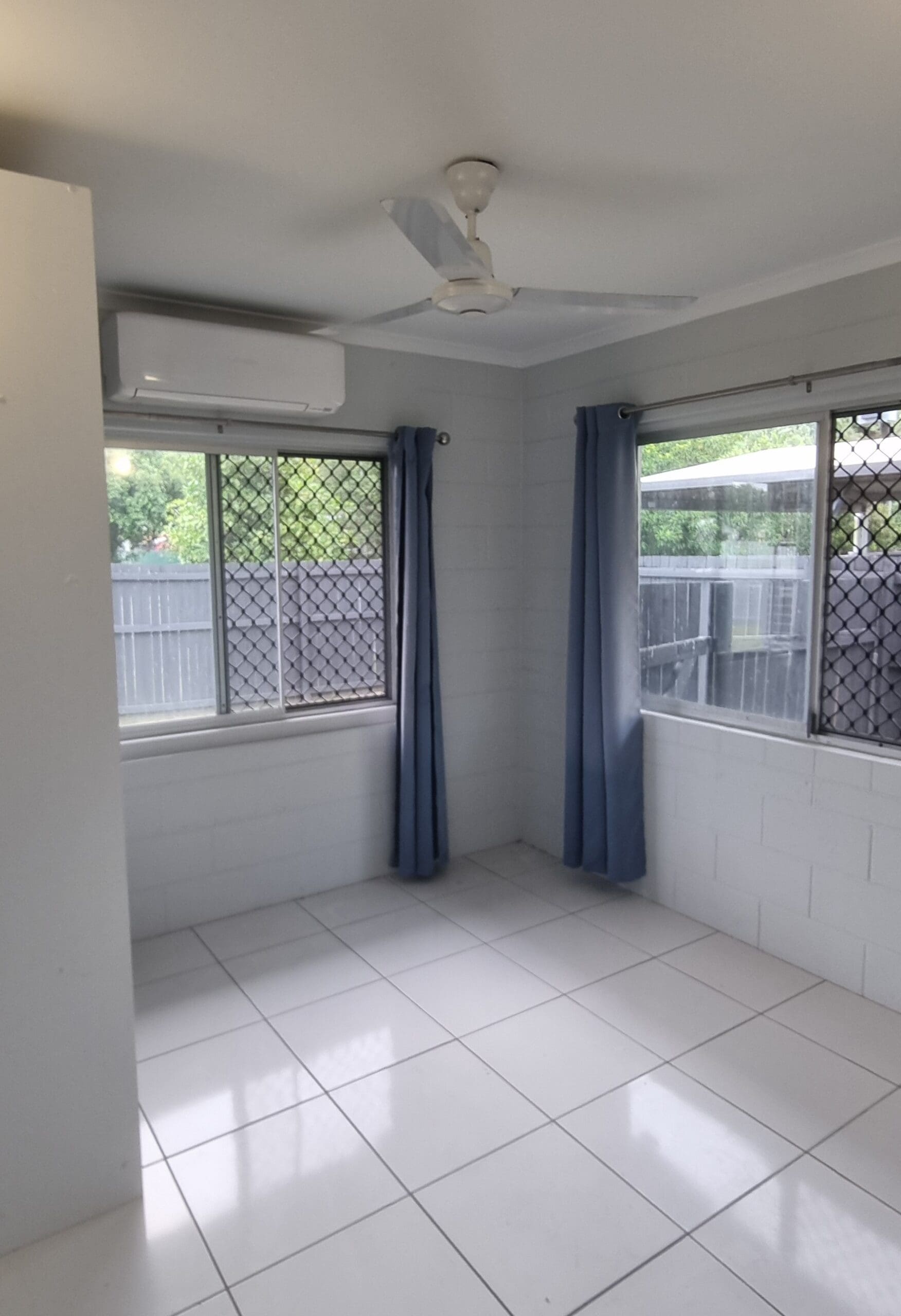Spacious, accessible room in a Comfortable and Cozy SIL in Cairns, 48 Swallow St, Mooroobool Qld 4870, featuring white tiles, large windows, and ceiling fan, part of Australia’s leading disability accommodation provider.