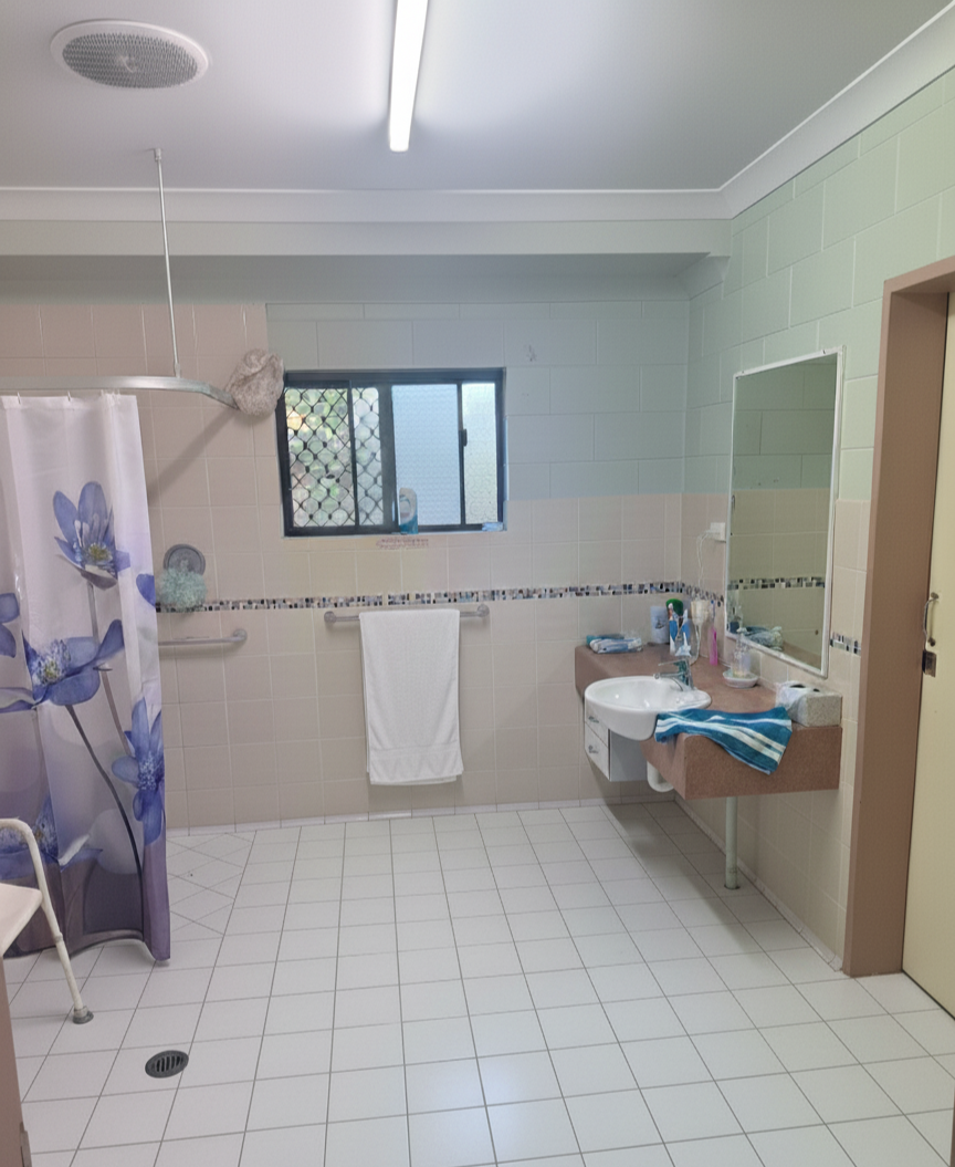 Accessible bathroom in a Central and Roomy SIL home in Mareeba, 6 Kylie Close, Mareeba 4880, featuring walk-in shower, grab rails, and wall-mounted sink, part of Australia’s leading disability accommodation provider.