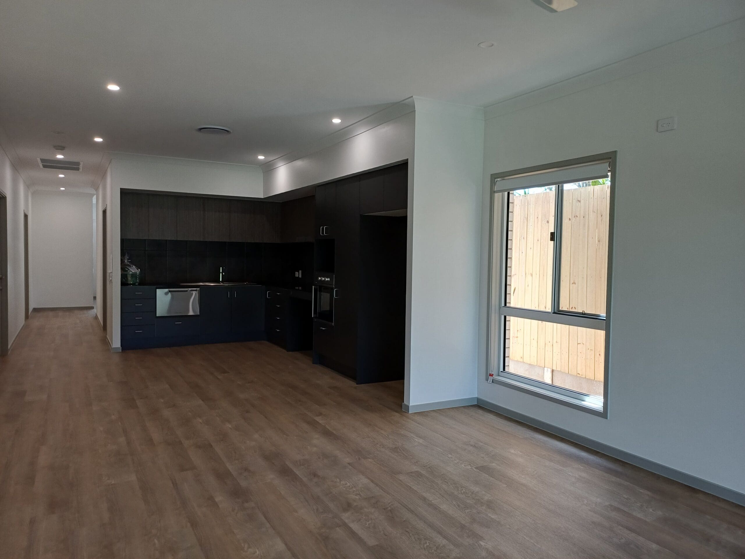 Spacious, accessible open-plan living area in Purpose-Built High Physical Support Living in Cleveland, Langdon Street, featuring modern kitchen, large window, and clear circulation, part of Australia’s leading disability accommodation provider.