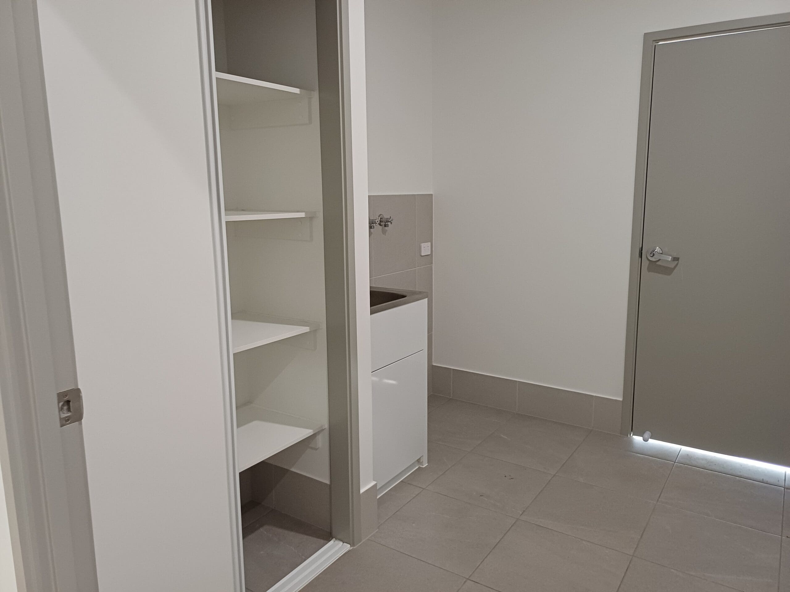 Accessible utility area in Purpose-Built High Physical Support Living in Cleveland, Langdon Street, featuring built-in storage, sink, and safety lighting, part of Australia’s leading disability accommodation provider.