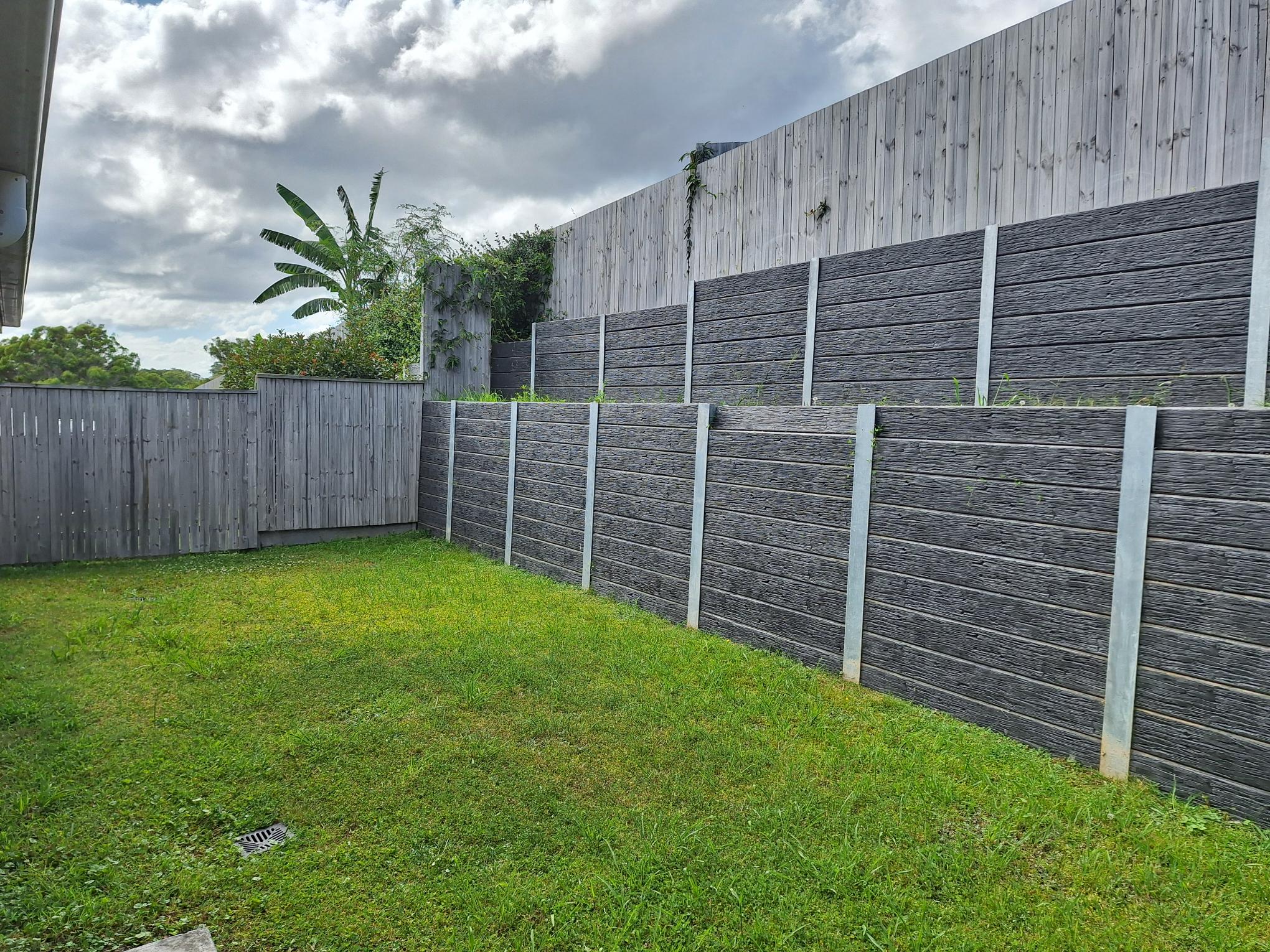 Private, accessible backyard of Comfort of SIL in Tranquil Thornlands, featuring lush lawn, secure fencing, and natural greenery, part of Australia’s leading disability accommodation provider.