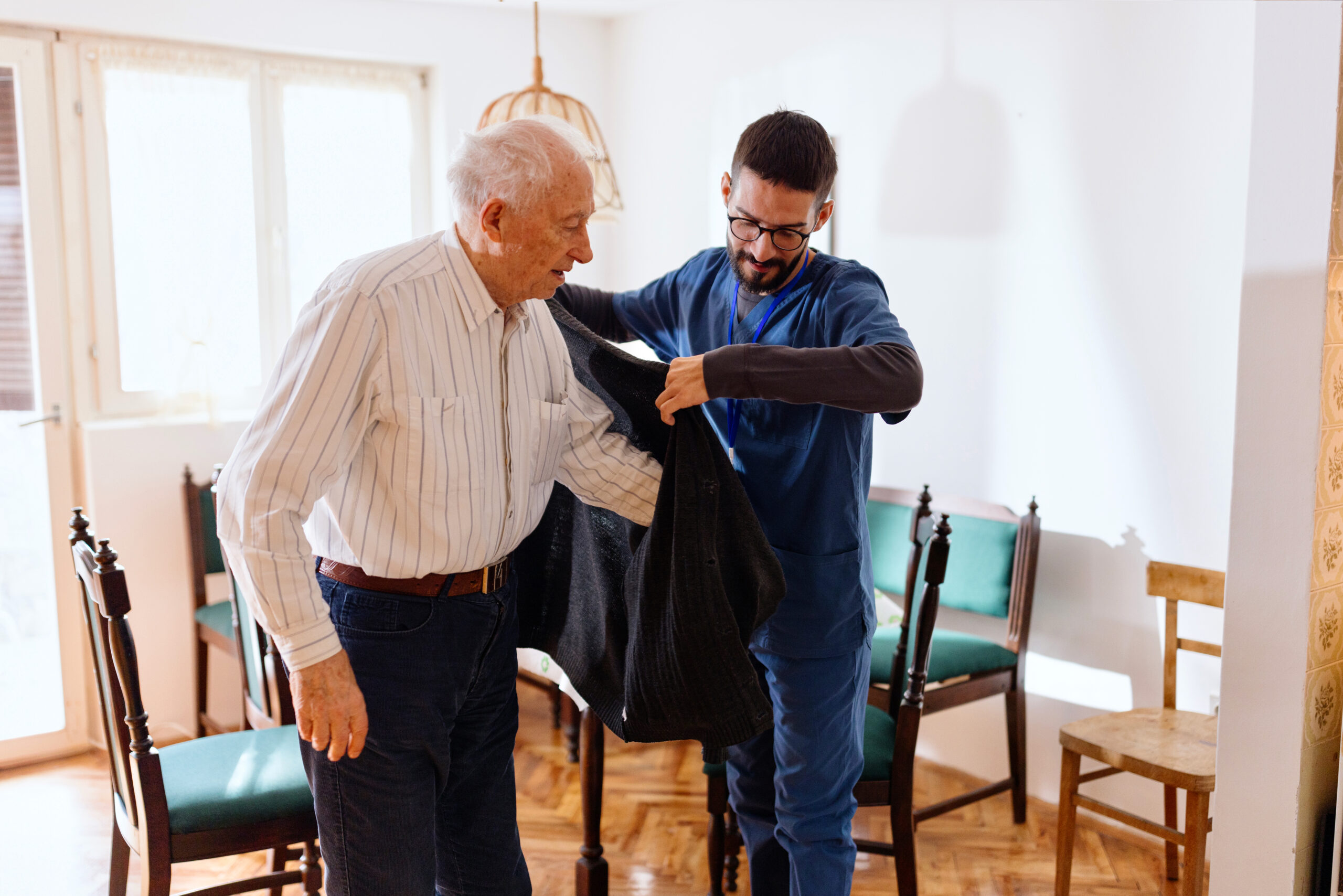 Male nurse providing care of a senior man at home